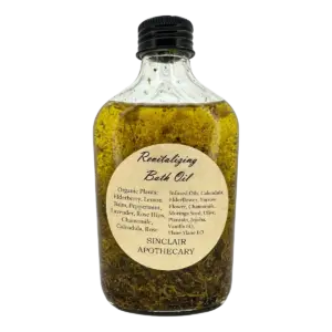 Bottle of Sinclair Apothecary organic revitalizing bath oil with herbs, flowers, and infused oils.
